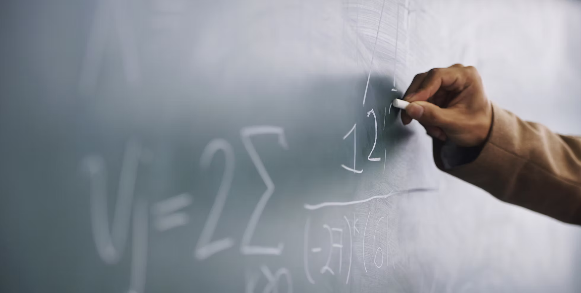 Profesor escribiendo una fórmula en una pizarra